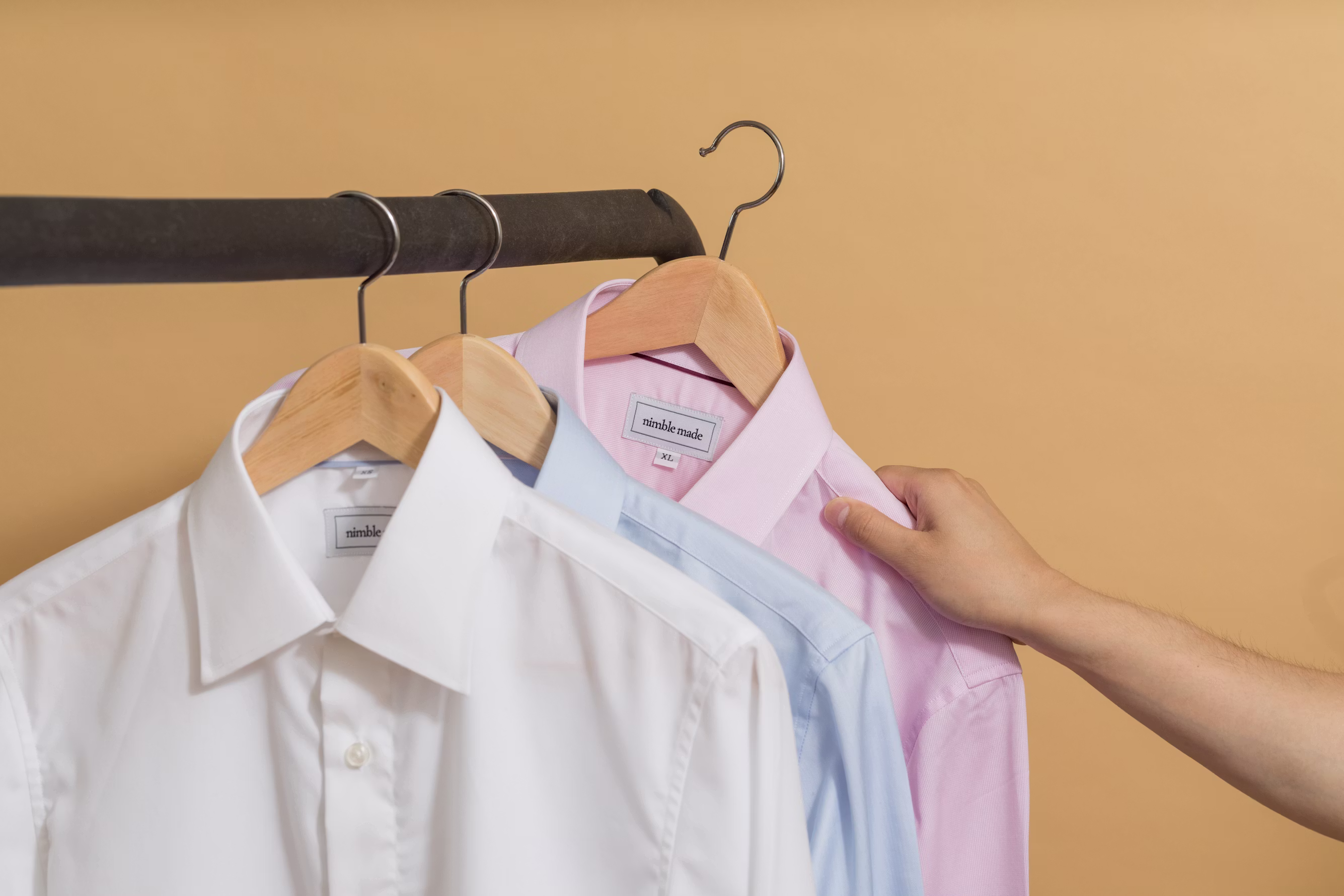 Dress shirts on wooden hangers, ready for formal wear care