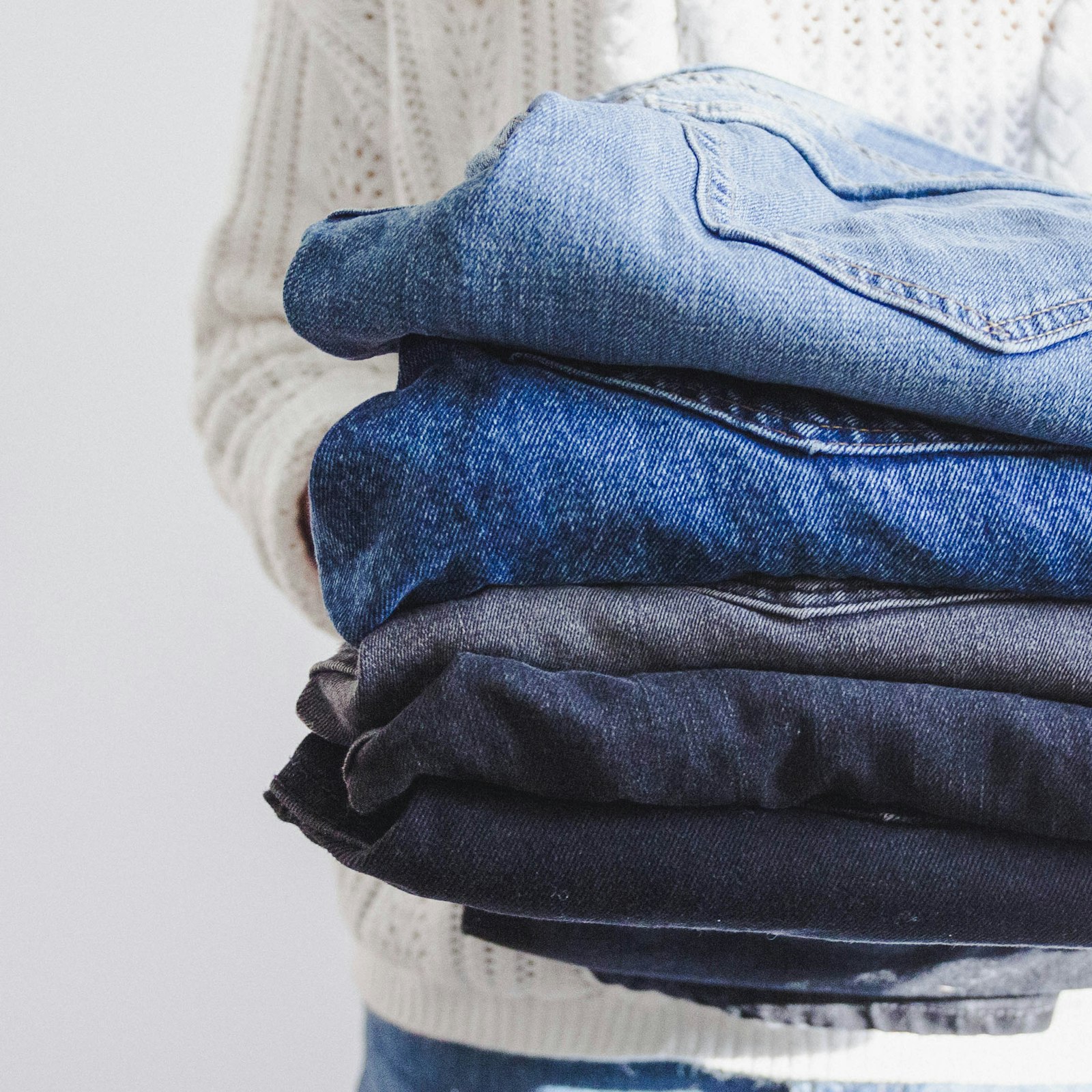 Neatly folded, freshly laundered clothes held in hand
